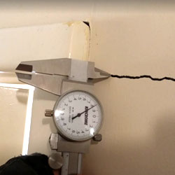 Crack in a wall being measured by calipers